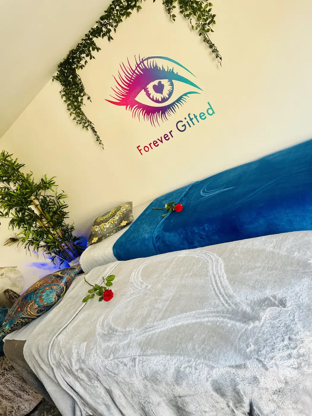 The massage bed made up with fresh linen and a single red rose