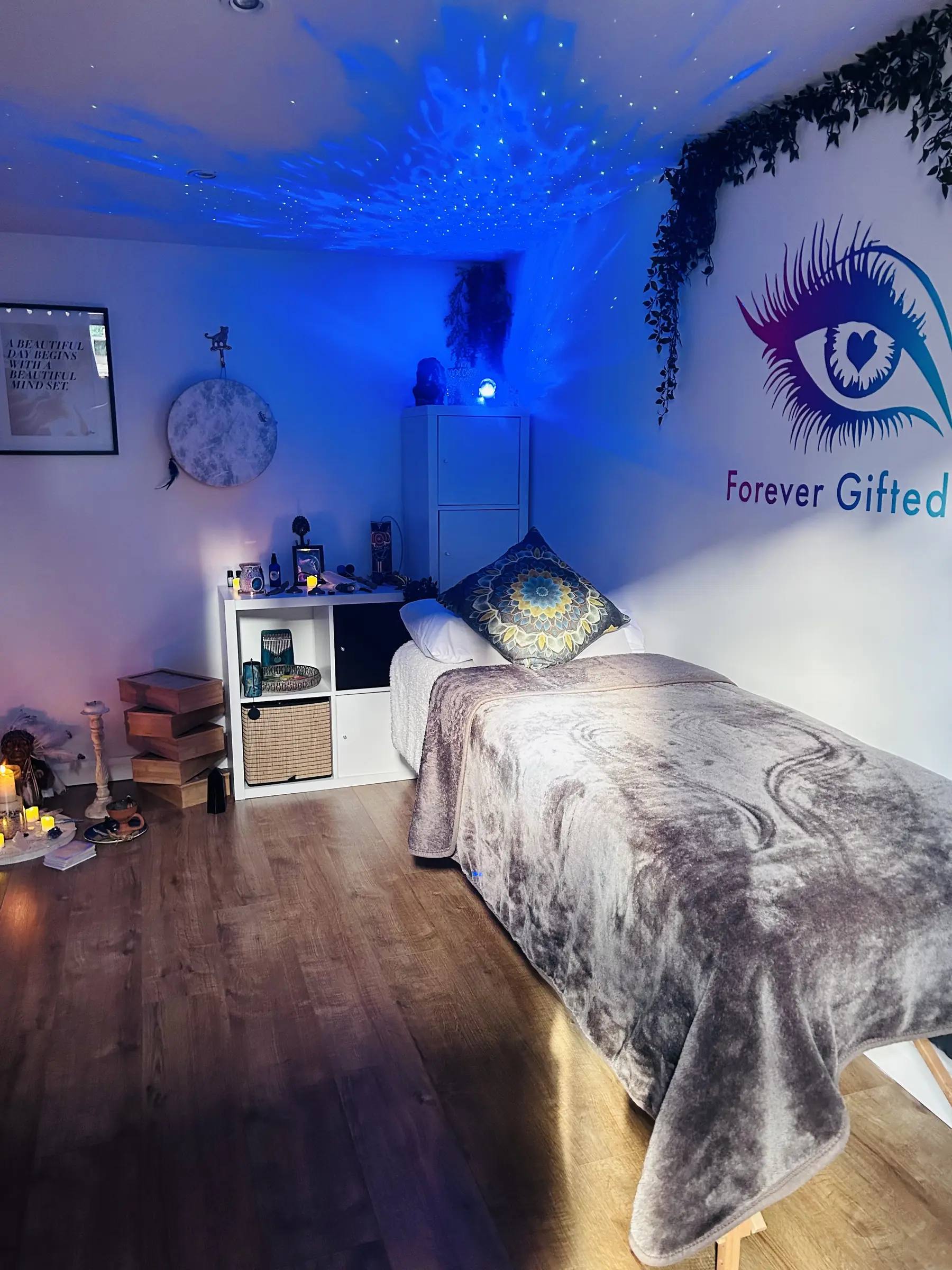 The cabin at night under soft blue light, the treatment bed made up beneath the Forever Gifted eye
