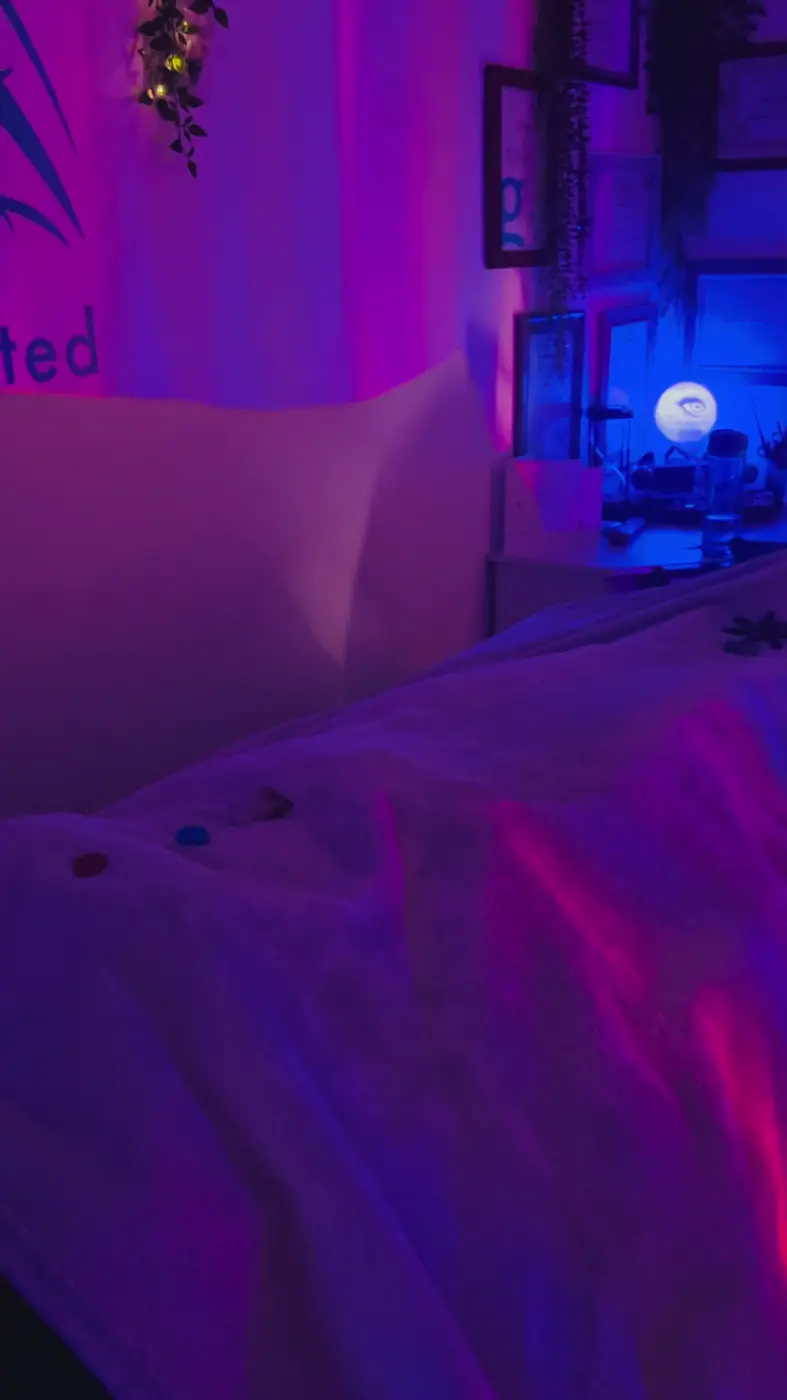 The treatment bed under purple light with chakra stones laid along the blanket