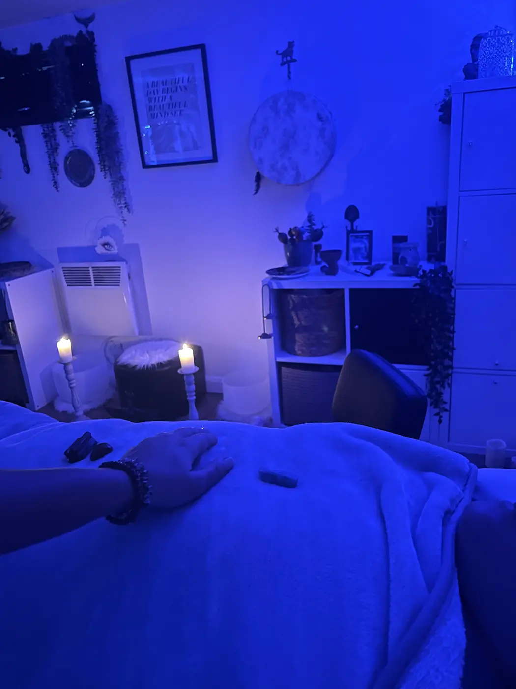 Filiz's hand resting gently on a client under blue light
